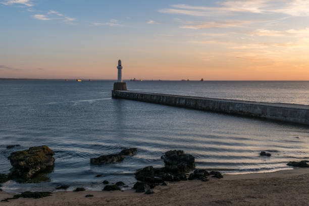 istock Sea wall, lighthouse, sunrise and ships. 844661980