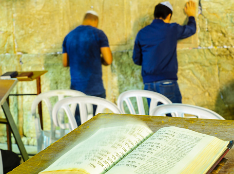 Jerusalem: Night scene of the Western Wall with the book of Psalm, Tehilim, and Jewish prayers, in Jerusalem, Israel. This is the holiest place in Jewish tradition