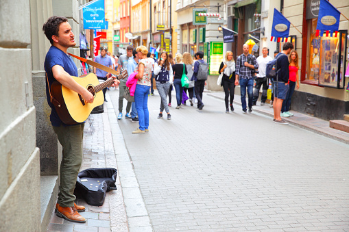 Stockholm, Sweden - July 25, 2017: Unidentified musician plays guiar in central shopping street of Gamla Stan in Stockholm