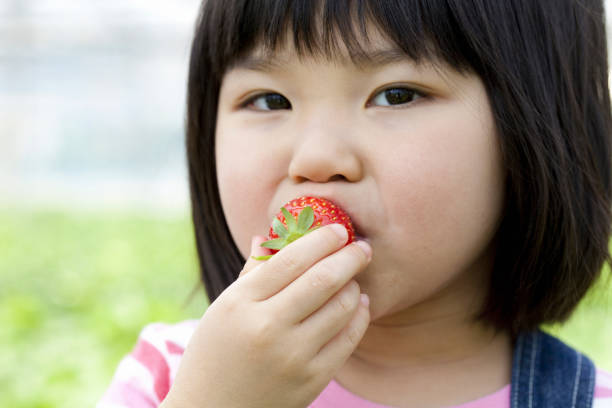 istock Girl eating strawberries 844734974