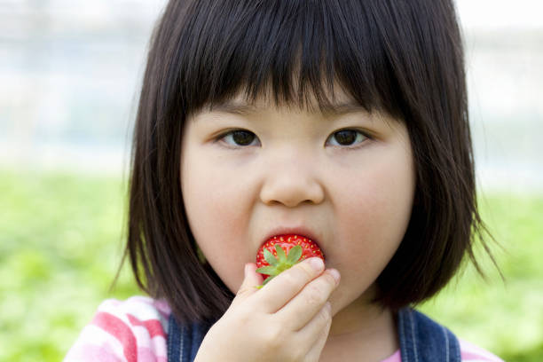 istock Girl eating strawberries 844734984