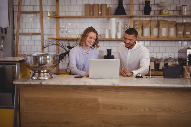 istock Young waitress and male owner using laptop at counter 844766060