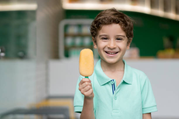 istock Happy boy eating a popsicle at an ice cream shop 844795982