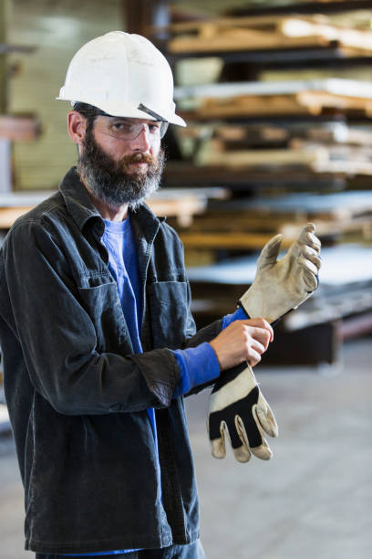 Worker in factory putting on gloves