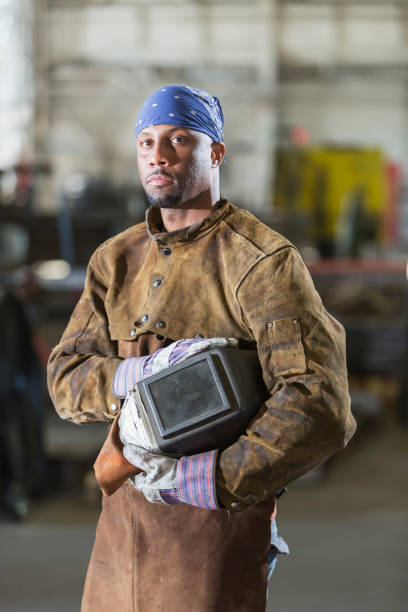 afrikanisch-amerikanischer mann arbeitet als schweißer - welder manual worker african descent steel worker stock-fotos und bilder