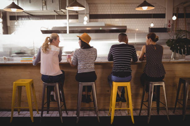 istock Rear view of friends sitting on stool at counter 844818234