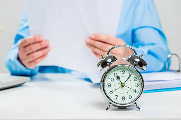 istock Accountant working in the office, alarm clock in focus close-up 844820482