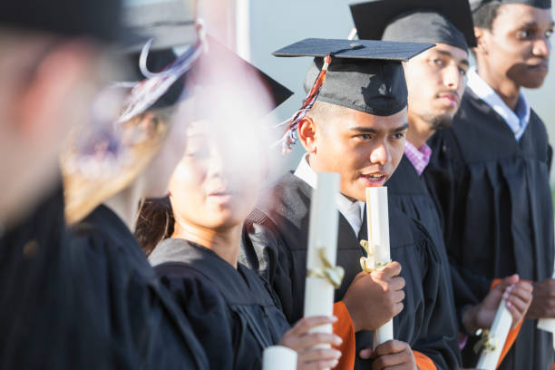 istock Multi-ethnic teenage graduates in cap and gown 844820492