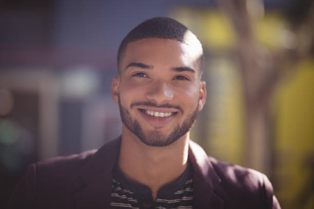 gros plan du sourire de jeune homme jour ensoleillé - male maroon head and shoulders close up photos et images de collection