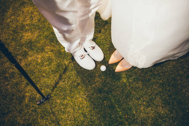 loving couple in wedding clothes playing Golf. Legs on green grass