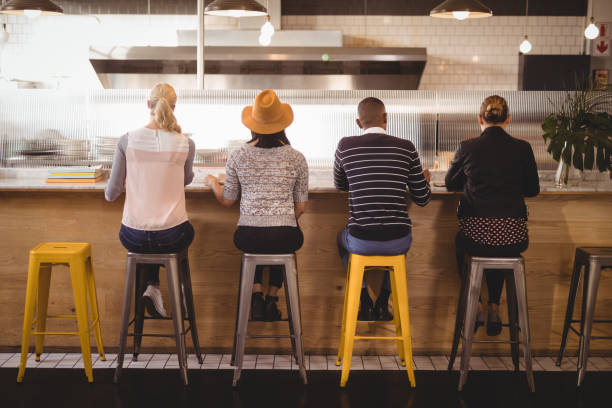 istock Rear view of customers sitting on stools at counter 844862736