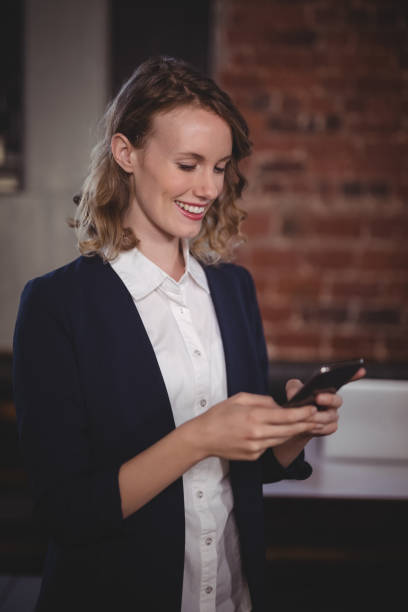 istock Smiling young beautiful female editor using smartphone at coffee shop 844883596