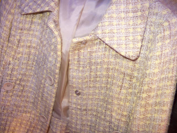 A grey striped gentleman's jacket with a white shirt, red bow tie and handkerchief on a taylor's dummy.