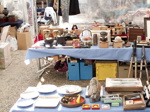 The weekend flea market on the city square in Cannes, France.  Vendors bring their merchandise of all types for sale at the weekend market.   The market is popular with tourist and residents alike.