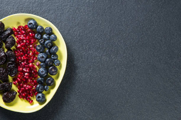Overhead view of various fruits in plate on slate