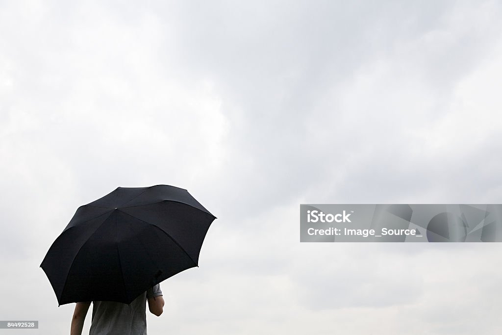 Homem segurando um guarda-chuva preto - Foto de stock de Guarda-chuva royalty-free