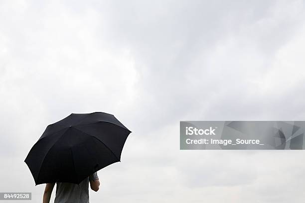 Foto de Homem Segurando Um Guardachuva Preto e mais fotos de stock de Guarda-chuva - Guarda-chuva, Homens, Cor Preta