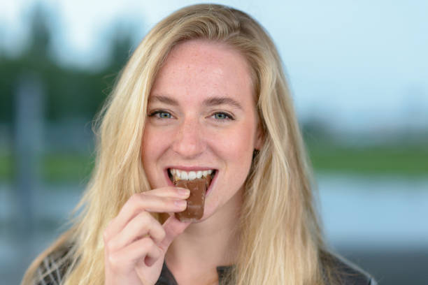 istock Cheerful blond woman eating chocolate 844946196