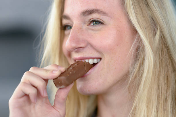 istock Cheerful blond woman eating chocolate 844946634