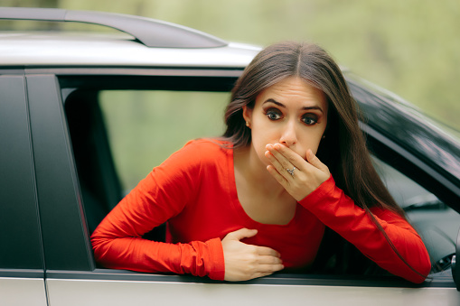 Suffering girl in a pulled over automobile trying to recover from travel sickness