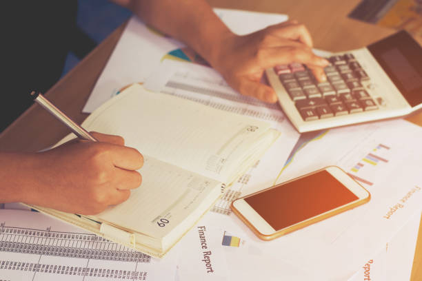 istock woman hand using calculator and writing make note with calculate,business concept 844973964