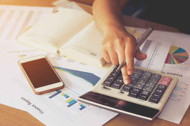 istock woman hand using calculator and writing make note with calculate,business concept 844991314