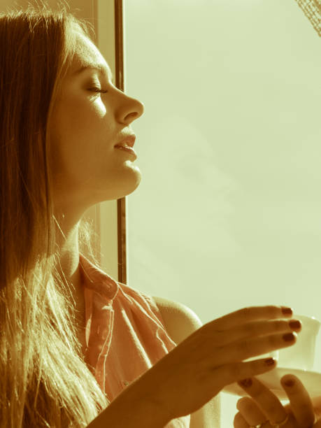 istock Woman looking through window, relaxing drinking coffee 844995058