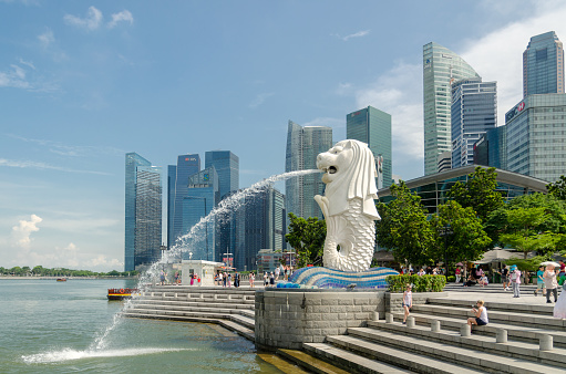 Singapore - May 5 : Merlion statue fountain with tourist in Merlion Park at Day light summer on May 5, 2017. Merlion fountain is one of the most famous tourist attraction in Singapore.