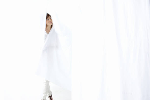 istock Women smile through the curtains 845012048