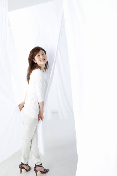 istock Women smile through the curtains 845012266