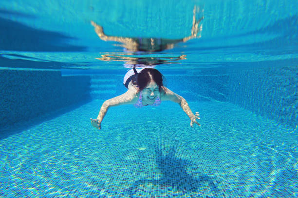 istock Young asian woman having fun underwater in swimming pool. 845027498