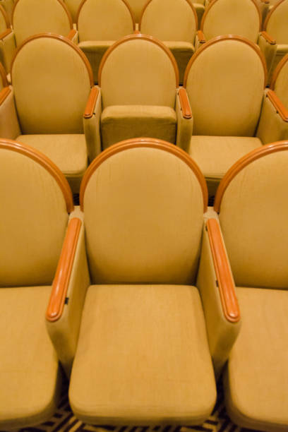 istock Cinema audience hall with golden row arranged armchairs 845051880