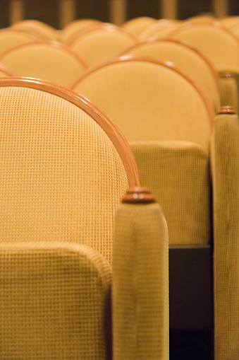 Golden armchairs in small cinema hall. Close up vertical composition