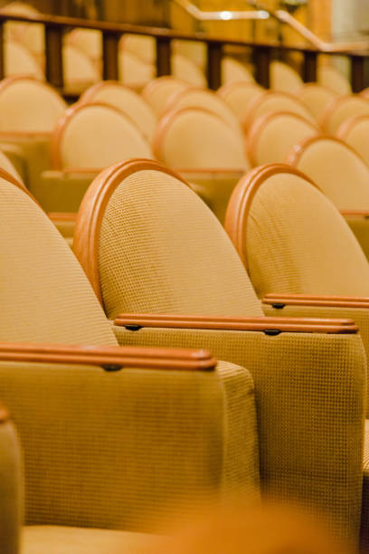 istock Cinema audience hall with golden row arranged armchairs 845051960