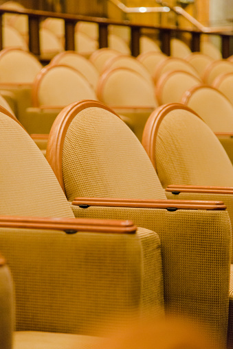 Golden armchairs in small cinema hall. Close up vertical composition