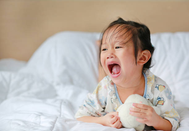istock Cute little girl with teddy bear lying on bed. 845059522