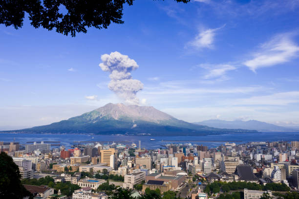 噴煙を上げる桜島と鹿児島市街 - erupting ストックフォトと画像