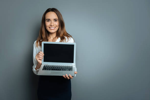istock Delighted nice woman showing you her laptop 845078588