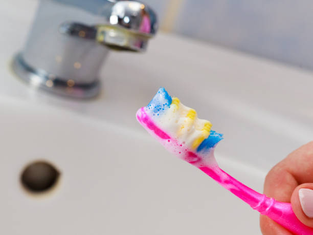 istock Hand holding toothbrush in bathroom 845084534