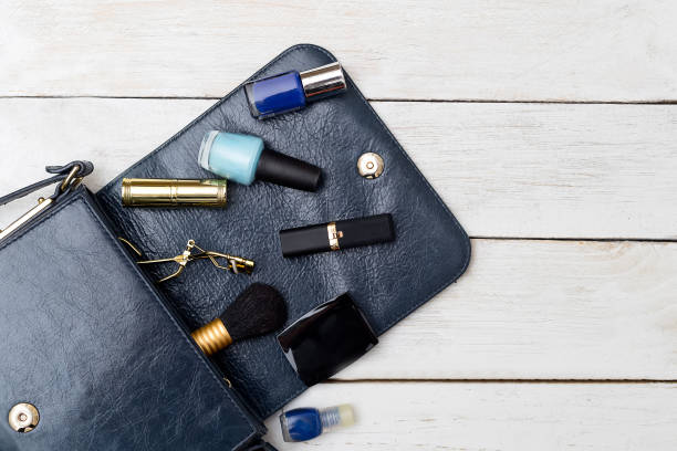 istock Cosmetics in a dark blue handbag on a white wooden background 845102470