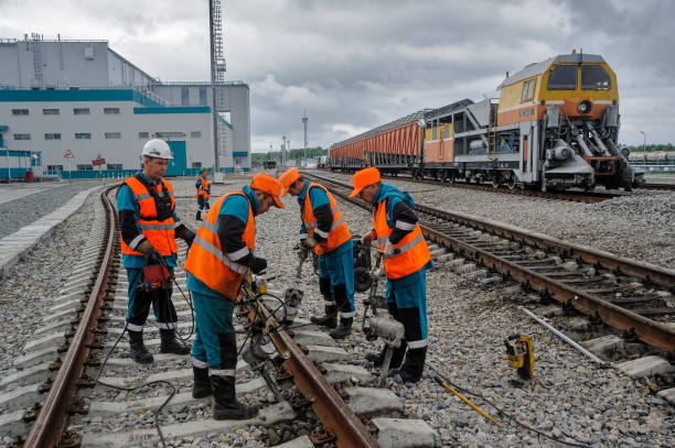 Railway workers repairing rail in rain stock photo