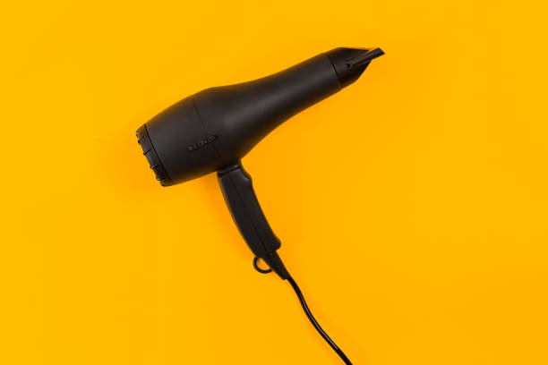 istock Black hair dryer on yellow paper background 845114592