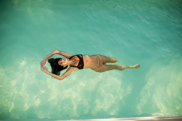 istock Woman in bikini  floating on water in the pool 845114762