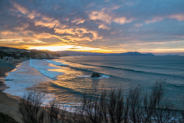 Surfers in Sopelana beach at dusk Surfers in Sopelana beach at dusk, Basque Country sopelana stock pictures, royalty-free photos & images
