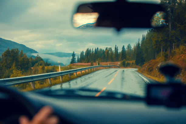 conduire une voiture sur la route de montagne. route des montagnes avec le ciel nuageux orageux dramatique. paysage. belle nature norvège. - car street horizon over land sky photos et images de collection