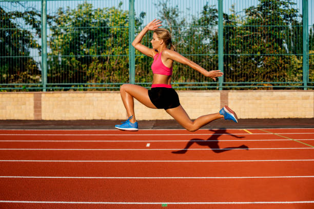 istock Side view beautiful young woman exercise jogging and running on athletic track on stadium 845126624