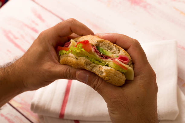 istock close-up a man holding a sandwich 845130686