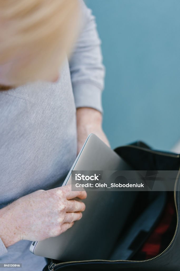 Putting Laptop In Backpack Man Putting Laptop In Backpack On The Cerulean Blue Background Stock