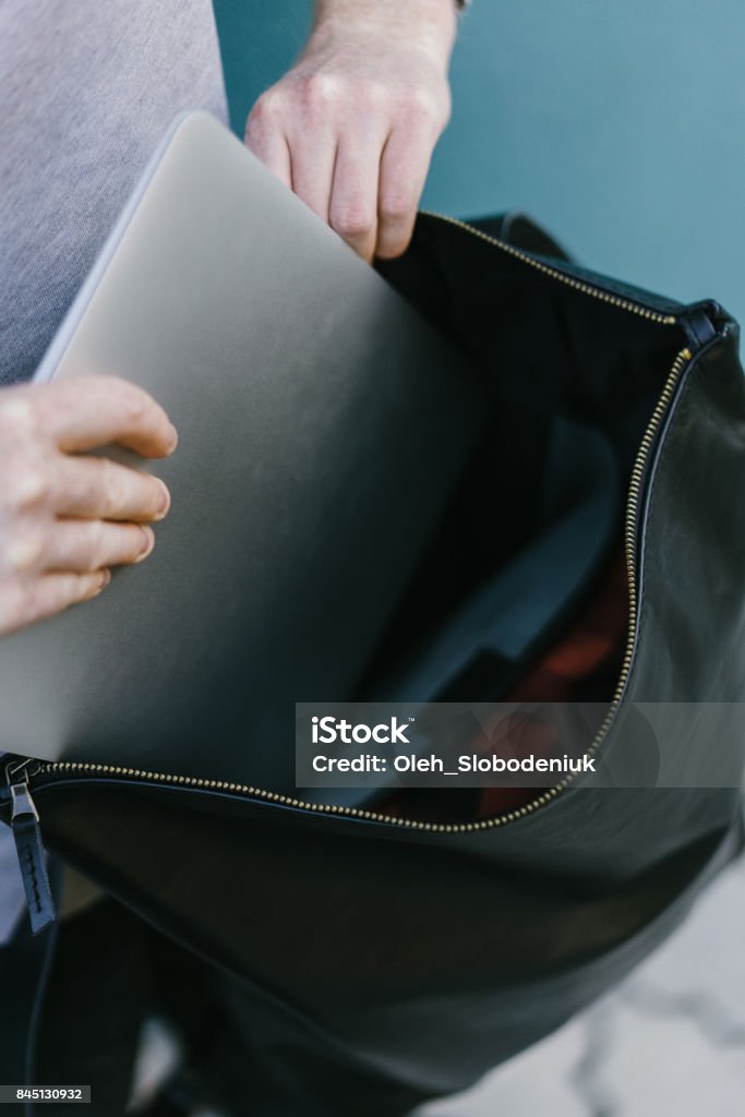 Putting Laptop In Backpack Man Putting Laptop In Backpack On The Cerulean Blue Background Stock