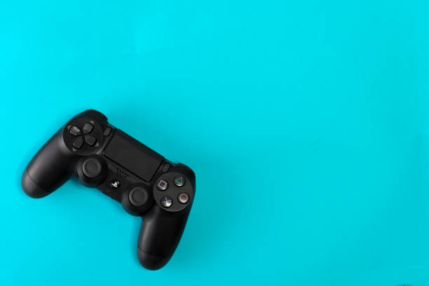 Sony PlayStation 4 Slim 1Tb revision and game controller on blue background stock photo